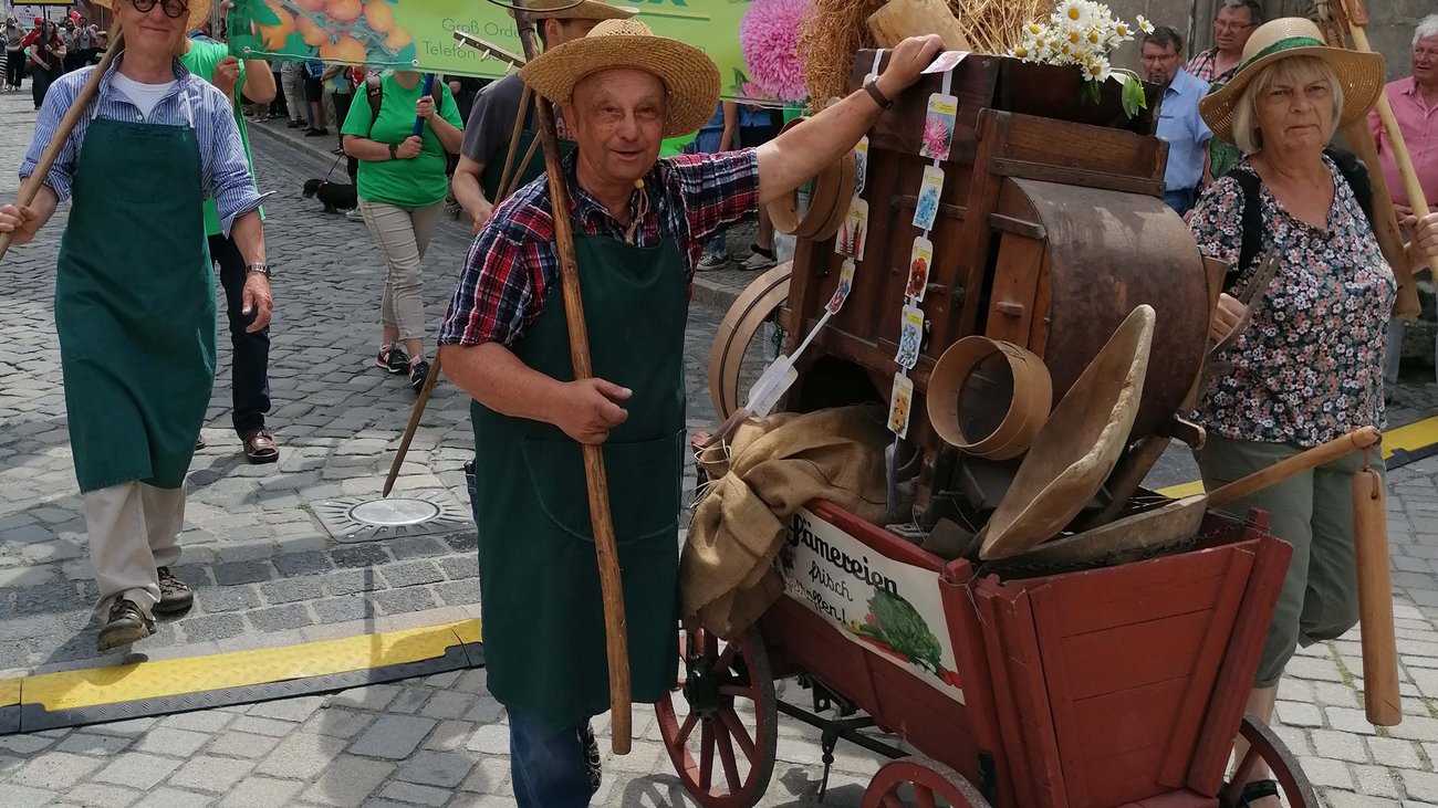 Personen mit Stroh&uuml;ten und Handwagen