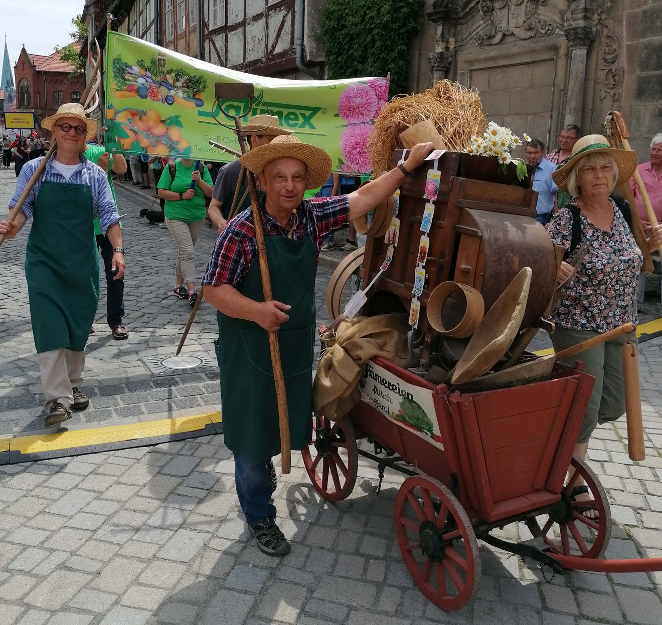 Personen mit Stroh&uuml;ten und Handwagen